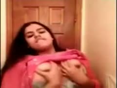 In a pink saree, a seductive Indian beauty boasts about her enormous, expensive breasts.